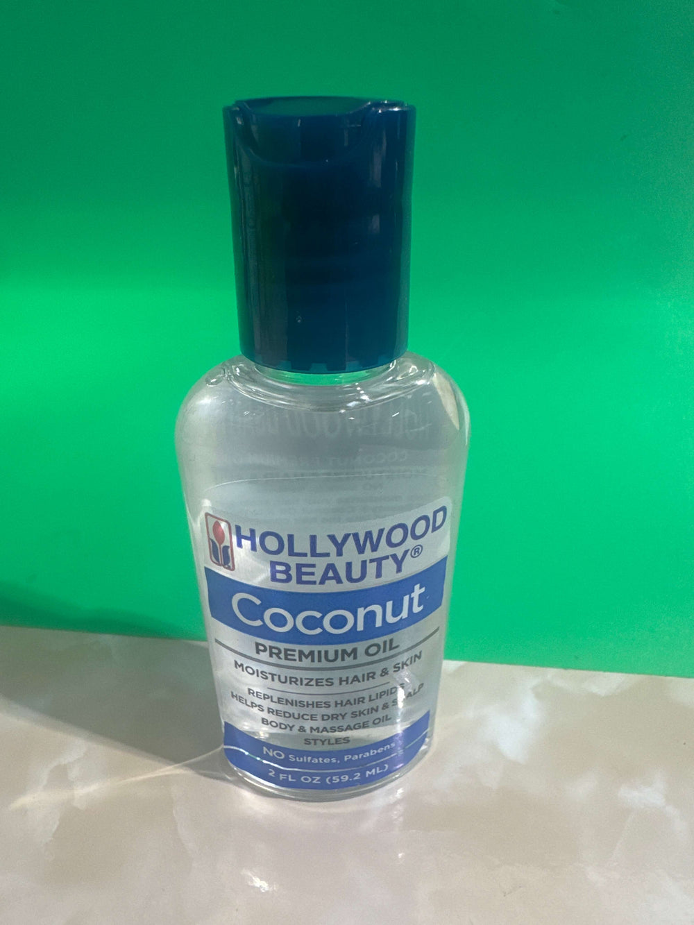 Bottle of Hollywood Beauty Coconut Premium Oil on a white background
